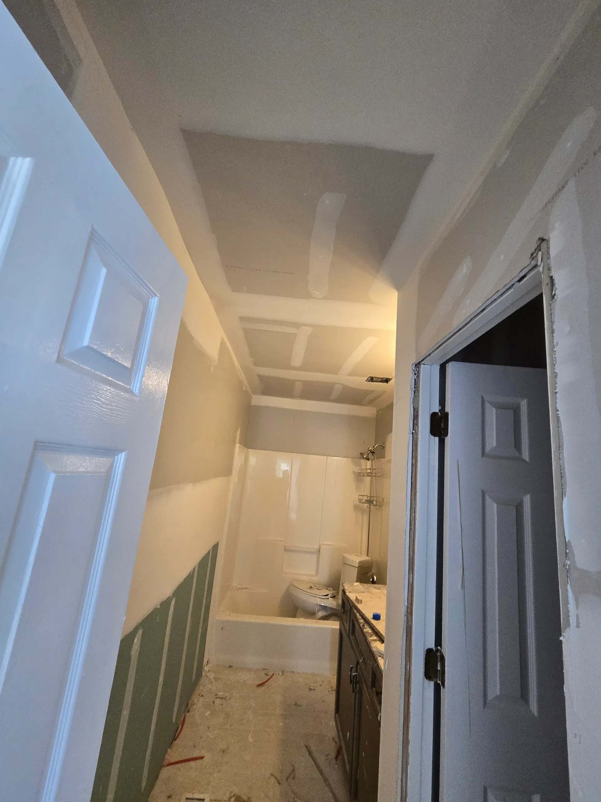 Bathroom renovation with taped drywall, a shower insert, and a vanity.